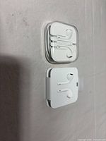 Two EarPods packages side by side, one in clear case, one in folded white tray