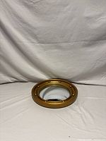 Front view showing gold porthole frame and convex mirror