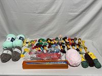 Entire lot overview of yarn skeins, embroidery floss, knitting needles, storage box