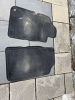Two large contoured carpet mats showing wear