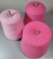 three pink yarn cones