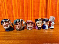Front view of all six miniature character jugs