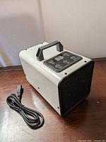 Full view of Tesiplz SMJ-218 ozone generator with power cord placed alongside