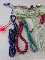 Overview of multiple loose bead strands with coloured tassels