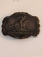 Front view showing cowboy motif, Winchester banner, 1902 date