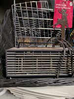 Front view of GE heater inside black basket with wire dish rack and wreath hanger visible