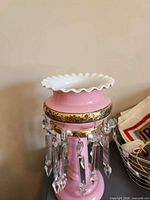 Full view of lustre lamp showing ruffled white rim, pink body and attached prisms