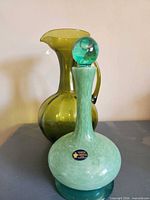 Bottle with stopper in front of pitcher