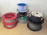 Group of six cable spools showing different reel colors and cable types
