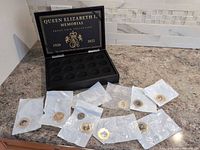 Open presentation box with nine bagged coins in front