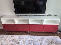 Front view of full TV stand showing doors, cubbies, legs