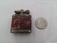 Front view showing lighter size next to quarter, red mottled panels