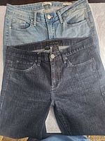 Both pairs of jeans full view overlapped
