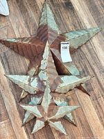 Three metal stars laid on floor showing sizes and finish