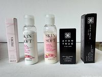 Front view of five boxed/bottled Avon items standing side by side