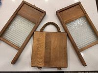 Group shot of two glass insert wooden washboards and one solid wood board with rope handle