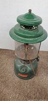 Front view of green Coleman lantern showing overall form and condition