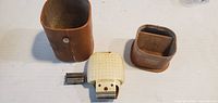 Shaver, leather case, inner sleeve, two cutter heads displayed