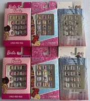 Front view of six packaged press-on nail sets showing brands and designs