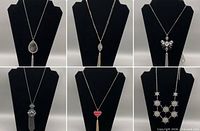 Collage showing all six necklaces on display forms