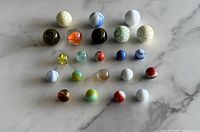 Full group of 22 assorted marbles on surface