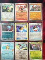 Nine sleeved Pokémon cards in a 3×3 binder page