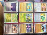 Binder page showing eight holographic/reverse holo Pokémon cards in sleeves