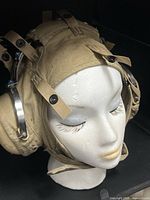 Front left view of khaki cranial helmet liner on mannequin head