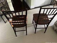 Back view of two dark brown Chiavari chairs