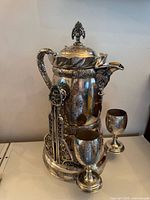 Full view of tilting pitcher on stand with both goblets visible