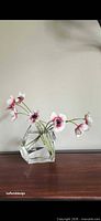 Vase displayed with flowers showing clear faceted design
