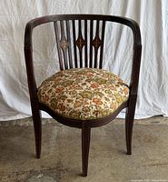 Front view of mahogany tub chair showing overall form and upholstery