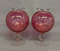 Front view of both cranberry etched glass pedestal bowls