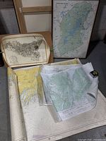 Overall lot showing framed Quebec map, Sicily map and rolled charts
