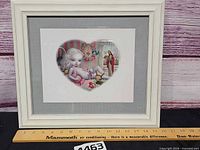 Full view of framed print with ruler indicating size
