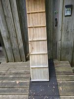 Full front view of wooden slat toboggan leaning against wall