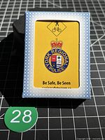 Front of boxed deck showing crest, safety message and yellow background