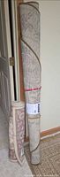 Both rolled rugs standing: long runner and shorter round rug