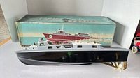 Starboard side view of model boat in front of original box