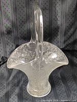 Front angled view of clear crackle glass basket vase with handle
