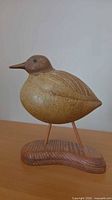 Front view of ceramic bird on wood base