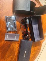 All items laid out: sunglasses, case, box, cloth, booklet