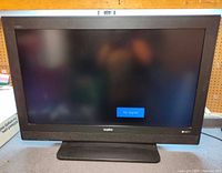 Front view of Sanyo DP42647 powered on, screen shows No Signal, pedestal stand visible