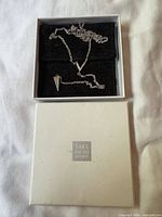 Necklace coiled inside branded white box