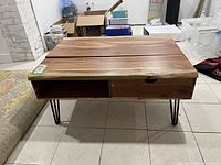 Front view of coffee table showing open shelf, drawer, and lift-top seams