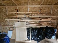 Overall view of shelves with pine boards, plywood panels and offcuts