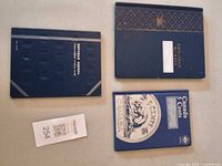 Three coin albums laid out closed showing covers