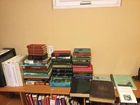 Wide view of desk with multiple stacks of books and binders