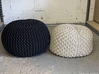 Black and cream knitted poufs side by side