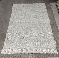 Full view of woven cream rug laid flat on floor